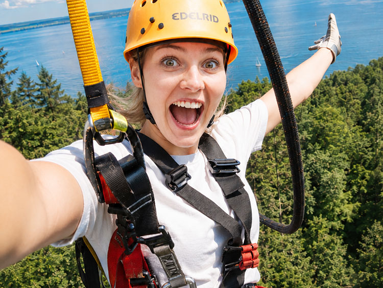 Eine Frau springt beim Basejump aufgeregt lachend ab
