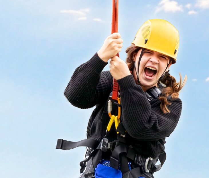 Eine Jugendliche schreit freudig beim Basejump Sprung