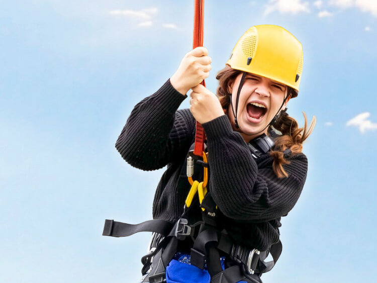 Eine Jugendliche schreit freudig beim Basejump Sprung