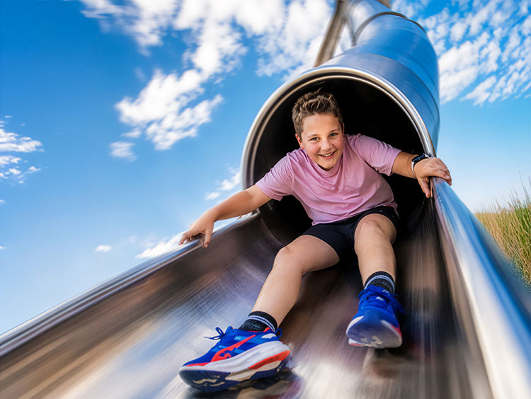 Ein Kind freut sich �ber die rasante Abfahrt mit der Mega-Rutsche