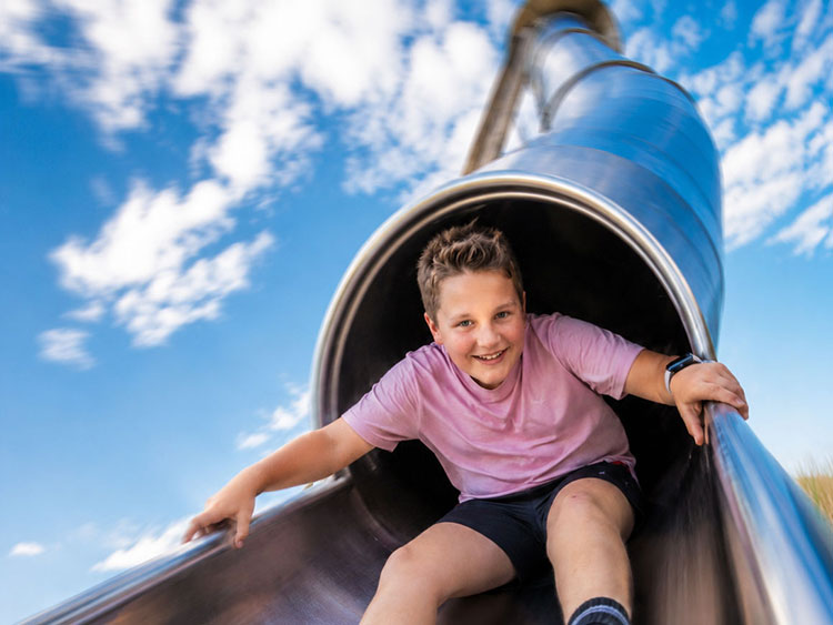 Ein Kind freut sich �ber die rasante Abfahrt mit der Mega-Rutsche