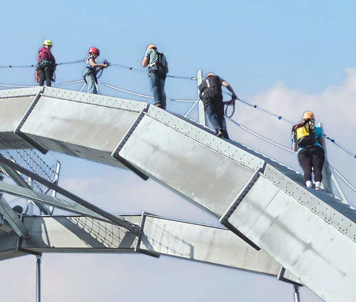Der Giantswing ist eine Riesenschaukel, die alleine oder zu zweit erlebt werden kann Kollegen erklimmen gemeinsam den 40 Meter hohen Klettersteig SkyTrail am Steinhuder Meer
