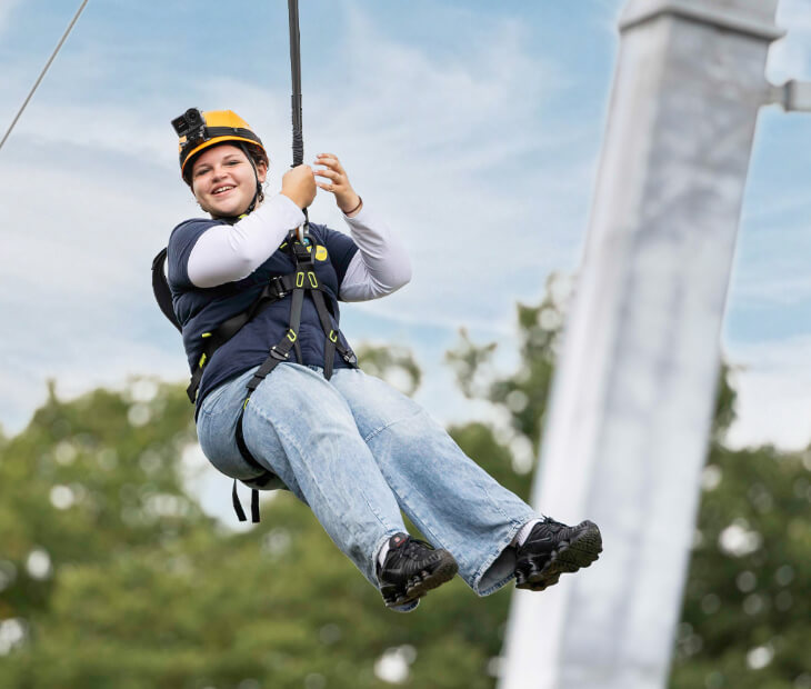 Eine Jugendliche genie�t aufgeregt lachend ihre Fahrt mit der Zipline