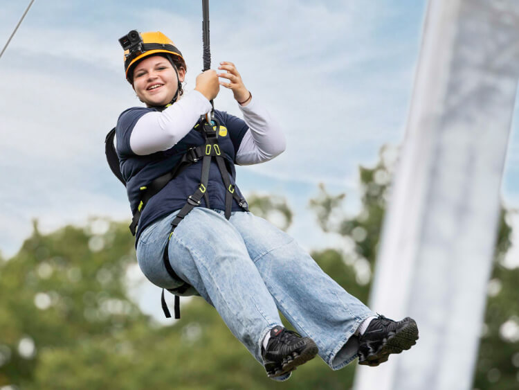 Eine Jugendliche genie�t aufgeregt lachend ihre Fahrt mit der Zipline