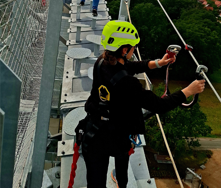 Eine Frau startet aufgeregt lachend in ihre Fahrt mit der Zipline