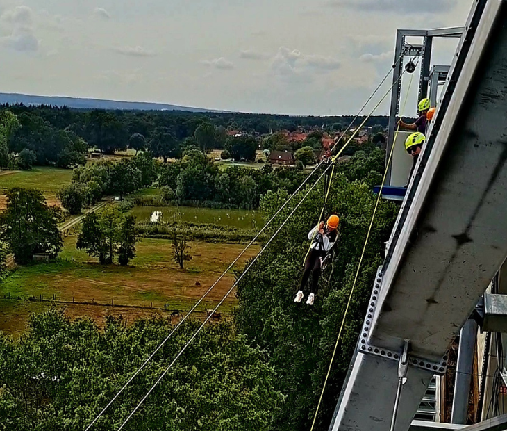 Eine Frau startet aufgeregt lachend in ihre Fahrt mit der Zipline