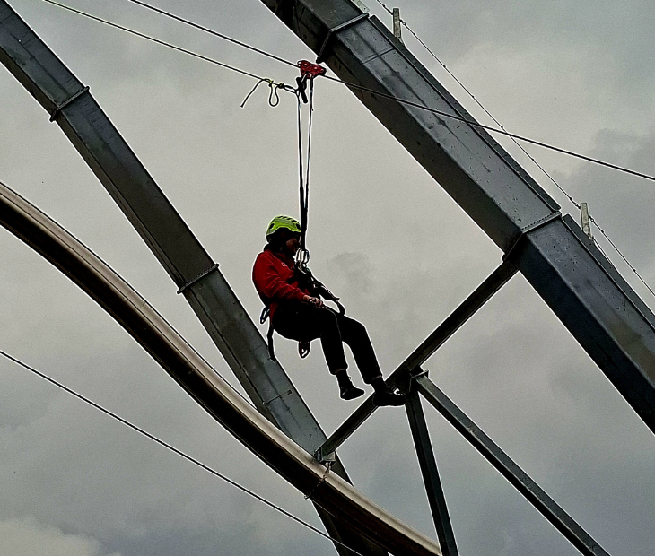 Eine Frau startet aufgeregt lachend in ihre Fahrt mit der Zipline
