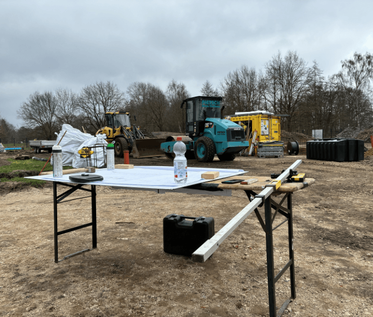 Baustellenmessung und Planung auf dem SkyLoop-Gel�nde in Mardorf mit Bauplan und Fundamenten im Hintergrund