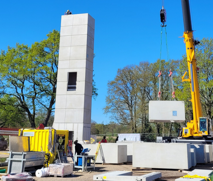 Hoher Rohbau des Aufzugsturms auf der SkyLoop-Baustelle in Mardorf mit Kran und weiteren Betonbauteilen