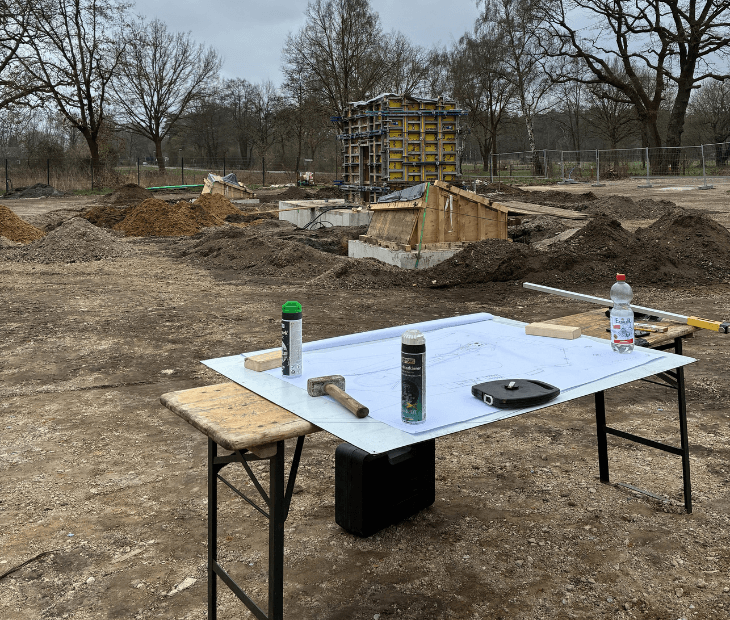 Baustellenplanung auf dem SkyLoop-Gel�nde in Mardorf mit Bauplan im Vordergrund und Maschinen im Hintergrund